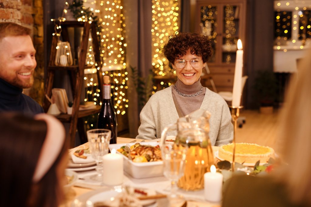 Woman at a party, sitting at a dinner table, happy and content