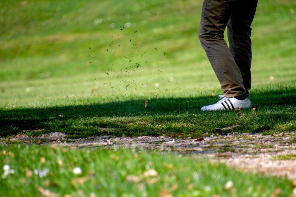 coloured picture of a man with golfing shoes, just after hitting the golf ball, representing just launching into business
