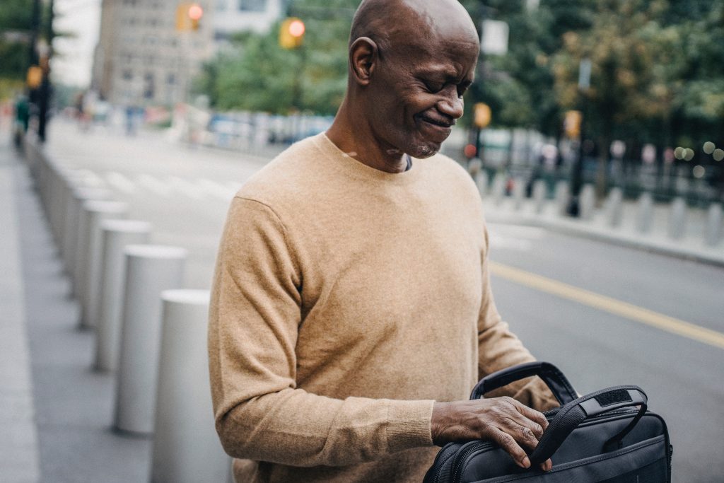 image of a man walking in the street looking into his bag, realising he has forgotten something - showing the value of a to do list in not forgetting things in business