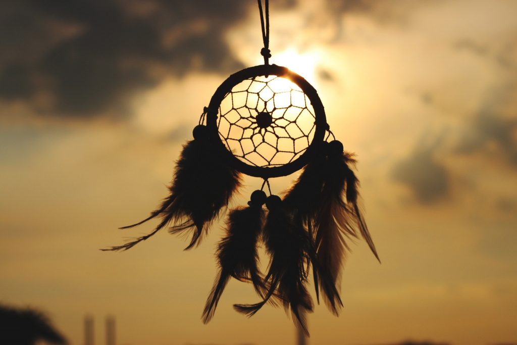 a picture of a dreamcatcher with the sun peeking through - talking about dreams in business