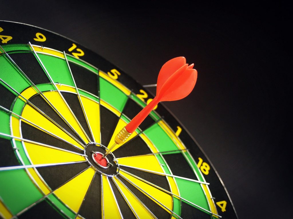 an image of a dart board with a bullseye shot - yellow and green board, representing perfectionism