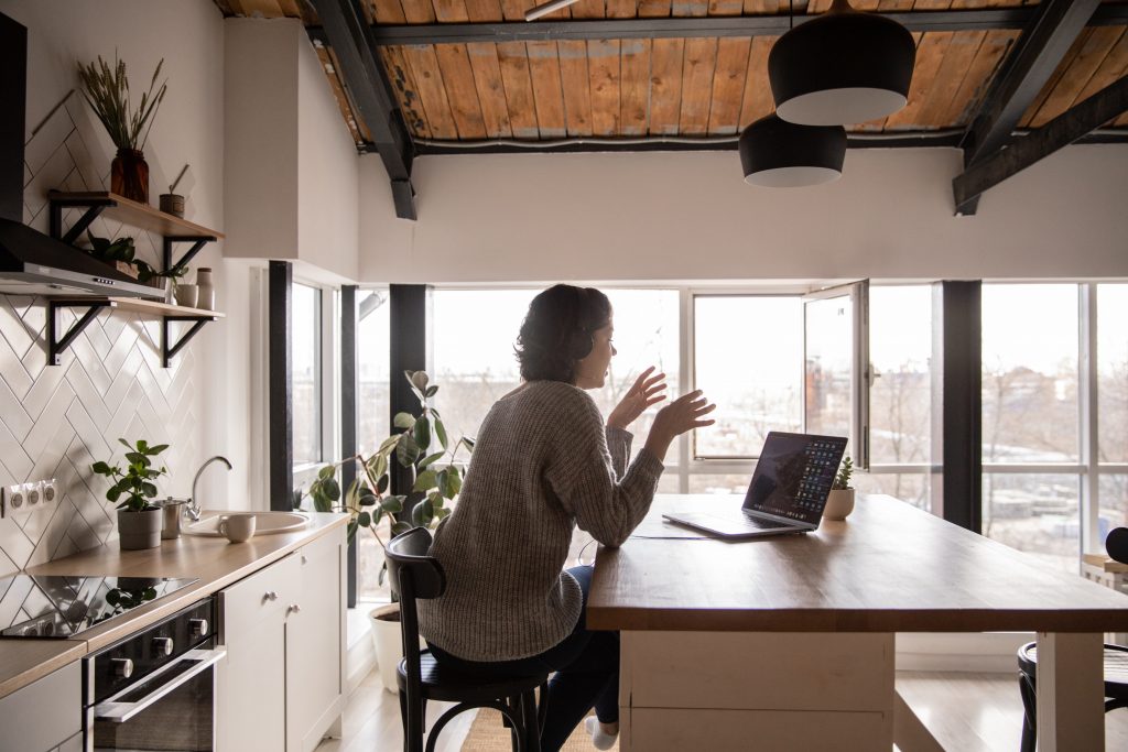 woman sittng at desk at home - delegating and communicating with staff
