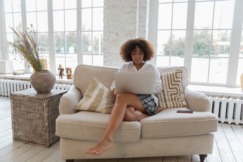 young business woman sitting on sofa with her laptop