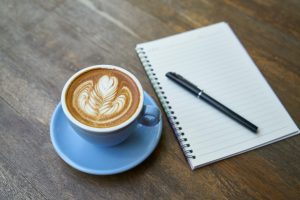 image of a cup of coffee and a notebook - symbolising work life balance and working holistically