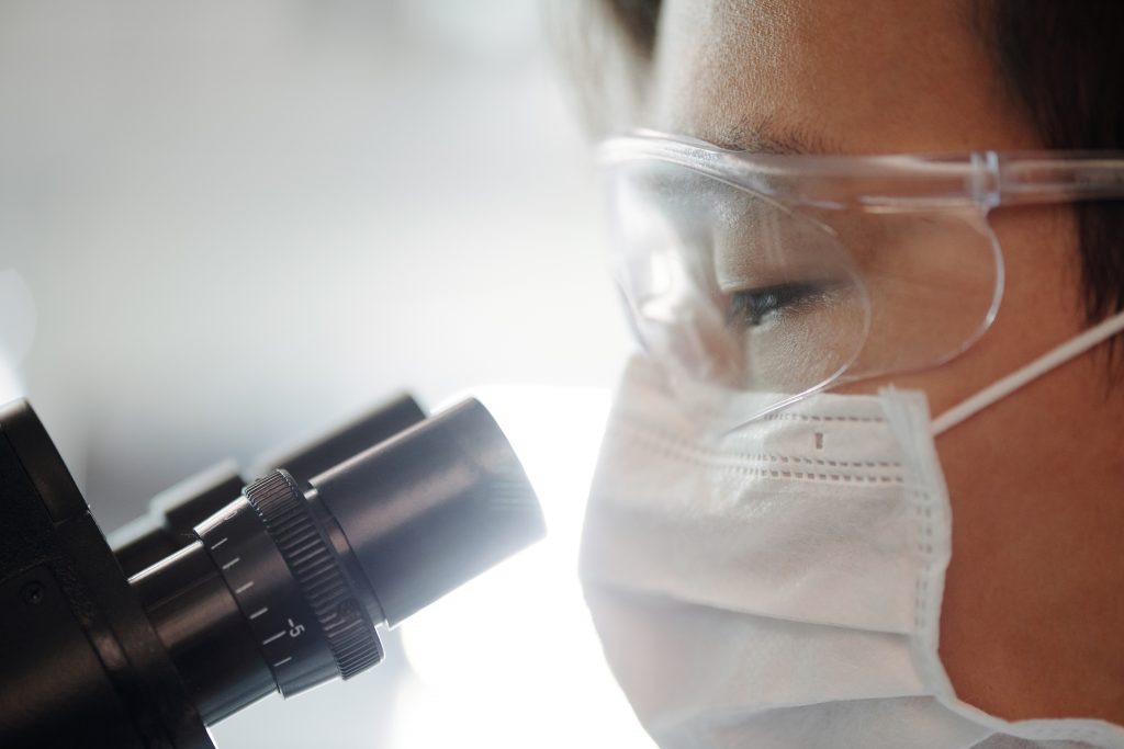 image of man looking into microscope; focus in business