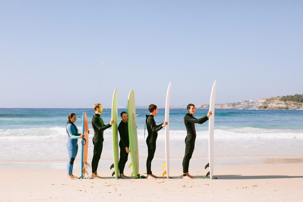 people with surfboards standing on a beach signifying business growth